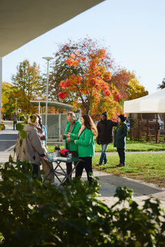 Male and female volunteers explaining about charity work to neighbors at public park