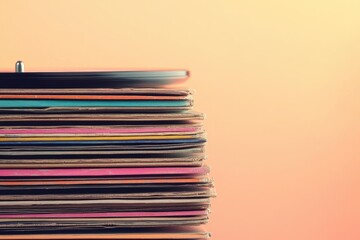 Stack of vintage vinyl records with colorful covers on a soft orange background, evoking nostalgia for music and retro culture.