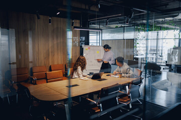 A diverse team is energetically brainstorming and collaborating together in a bright, contemporary office space