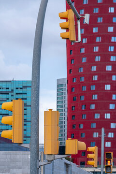 Traffic lights and curved post with colorful buildings in background, urban transportation system and regulation theme perfect for modern mobility and signage stock