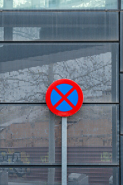 No parking sign in front of metallic facade with urban reflections, perfect detail for transportation, regulation and street design concepts in editorial and commercial projects