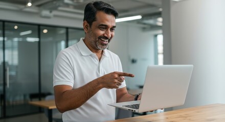 Smiling mature male using laptop: businessman engaged in video call in modern office