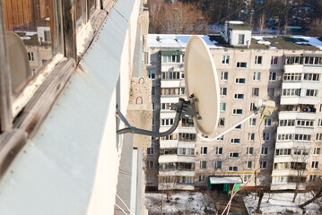 Satellite dish on the wall of the building.