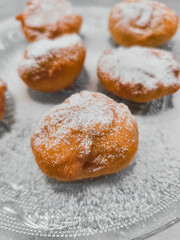 Delicious baursaki sprinkled with powdered sugar on glass plate in prague