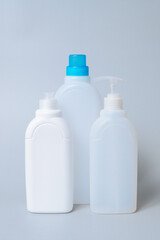 Plastic bottles with household cleaning products on a blue background, representing hygiene, cleanliness, and home care essentials