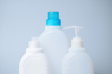 Plastic bottles with household cleaning products on a blue background, representing hygiene, cleanliness, and home care essentials