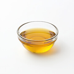 Golden oil glistening in a clear glass bowl, a simple yet elegant presentation against a bright white background.