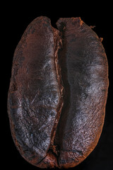 Naklejka premium Coffee bean in macro photography on a black background