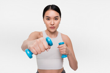 Strength Workout. Sporty Asian strong sporty athletic fitness gym trainer instructor coach woman in sportswear holding dumbbells doing boxing exercise over white background. Studio shot
