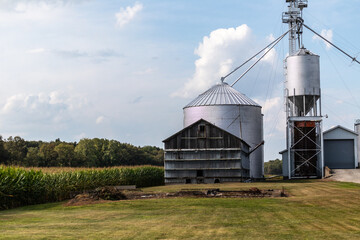 Farm silo and barn by a corn field in the American midwest in summer.  © K KStock