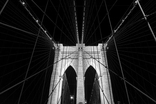 brooklyn bridge detail at night (manhattan east river crossing in the dark) illuminated historic landmark monument new york city icon (iconic suspension structure) tourism nightlife travel destination