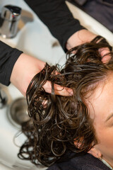 Fototapeta premium Person receiving a scalp massage at hair salon sink