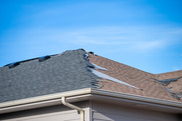 ground level view re-roofing overlay project at a residential house where new shingles are placed...