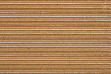 A close-up shot captures the texture of corrugated cardboard with horizontal grooves and slight white paper tears revealing its layered construction