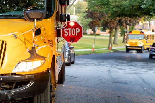 school bus on the road with stop sign out flashing red lights - Powered by Adobe