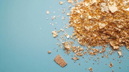 Shimmering gold flakes scattered on vibrant blue background crea