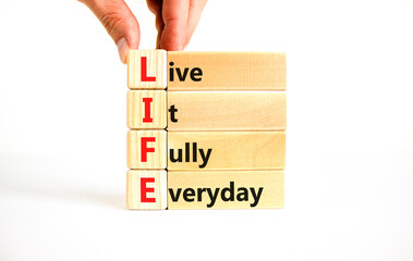 LIFE live it fully everyday symbol. Concept word LIFE Live It Fully Everyday on beautiful blocks....