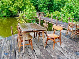 The outdoor restaurant's wooden chairs and table with a beautiful natural view of the mangrove forest in Jakarta, Indonesia