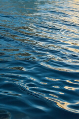 Close-up view of ocean surface with gentle waves and shimmering reflections of sunlight. Peaceful sea texture, natural water movement, perfect for backgrounds or relaxation themes.