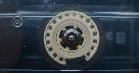 Macro Close Up of Magnetic Tape Reel on Audio Cassette Tape Spinning, Playing Retro Mixtapes or Analog Sound. Playback of Old Music Collection Using Hi-Fi Vintage Sound System. Reel Tape Recorder.