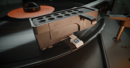 Vinyl Record Spinning On Vintage Turntable. Needle Gently Scratching Grooves, Playing Classic Music or Analog Sound on Vinyl Record Player. Retro Sound System with Nostalgic Aesthetic. Macro Close Up.