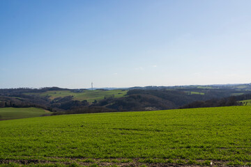 Panoramic photo of rural area with a lone wind turbine on the horizon. Green energy concept