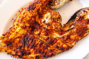 Spicy grilled grouper with a crispy charred surface, served in an Arabic restaurant in the UAE