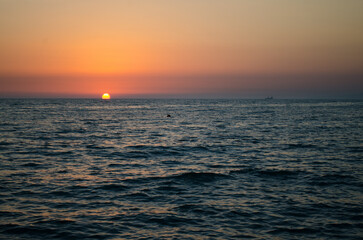 Dusk over tranquil ocean horizon with vibrant sunset