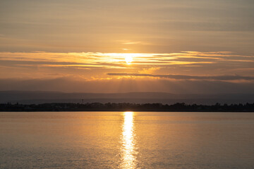 Fototapeta premium Sunset over the ocean, with the sun low on the horizon, contrast between sky and sea