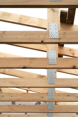 Making a wooden roof. Close-up wooden roof trusses in a frame structure. Steel beam connections. Wooden roof structure