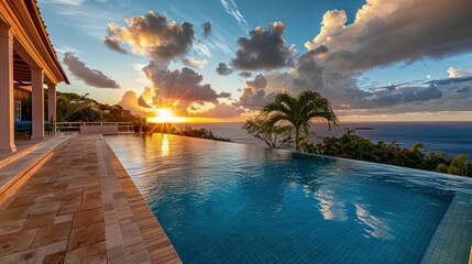 Obraz premium Stunning luxury villa with a spacious pool overlooking the ocean at sunset.