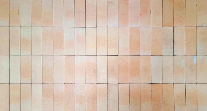 close-up, flat-lay view of a neatly arranged pattern of light terracotta brick tiles, highlighting their subtle texture, warm color variations, and geometric repetition. natural clay tile surfaces.