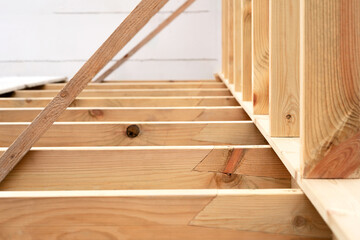 Making a wooden roof. Close-up wooden roof trusses in a frame structure. Steel beam connections. Wooden roof structure