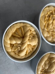 Unbaked traditional Ukrainian Easter bread with symbolic dough decoration in baking forms