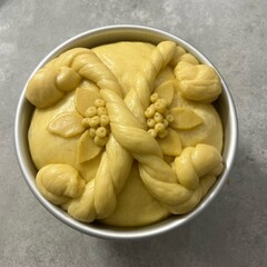Unbaked traditional Ukrainian Easter bread with symbolic dough decoration in baking forms