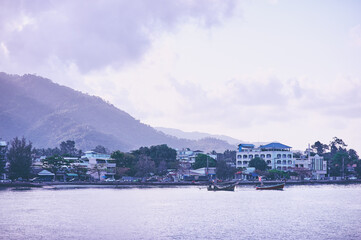 Coastal Village with Traditional Boats and Serene Mountainous Backdrop