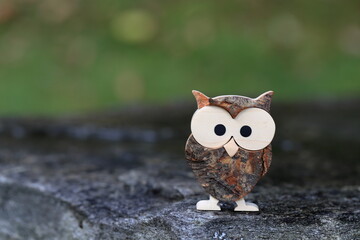 Statuina di un piccolo gufo con sfondo del giardino, bokeh