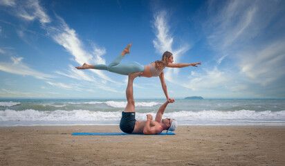 Sport man and woman exercise on beach at daytime