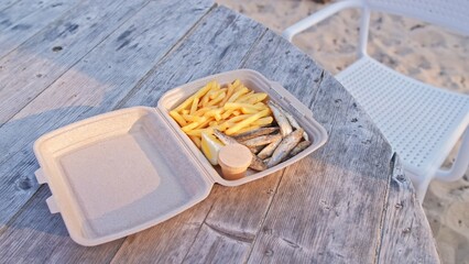 Fried Fish and Chips French Fries Fast Food Snack in Styrofoam Box Sold at Seaside Beach Bar
