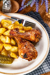 Baked chicken drumsticks with potatoes.