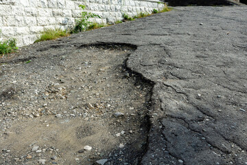 Old asphalt road leading to an abandoned historical building. The road to the top for climbing to a historical monument.