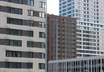 Naklejka premium Budget houses of different heights with smart apartments in dense urban development. Multi level parking surrounded by square apartments 