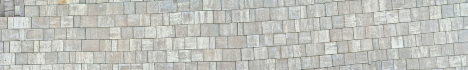 Close-up of textured stone pavement showcasing a natural, wavy pattern. Ideal for design, architecture, or landscaping visuals.
