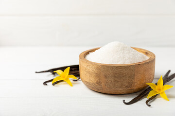 Aromatic vanilla sugar. Vanilla pods. Vanilla sticks, brown and white sugar in a bowl on a textured background. Vanilla flowers, spices and herbs for desserts and baking. Space for text. Copy space