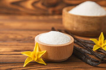Aromatic vanilla sugar. Vanilla pods. Vanilla sticks, brown and white sugar in a bowl on a textured background. Vanilla flowers, spices and herbs for desserts and baking. Space for text. Copy space