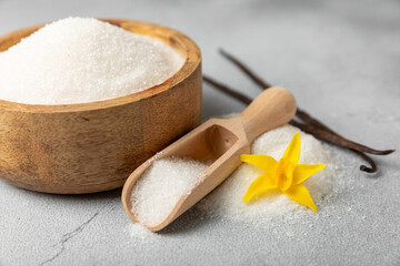 Aromatic vanilla sugar. Vanilla pods. Vanilla sticks, brown and white sugar in a bowl on a textured background. Vanilla flowers, spices and herbs for desserts and baking. Space for text. Copy space