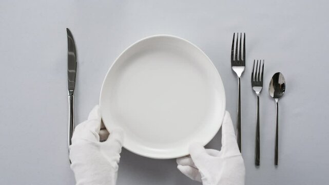 Fancy restaurant, waiter Elegant table setting with white square plate and silverware, arranged for sophisticated dining