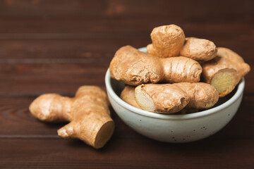 Fresh ginger on wooden background. Dry ginger. Sliced ​​ginger with honey and lemon. Ginger root. Traditional alternative medicine, healing tea for immunity. Seasoning and spices concept. Copy space.