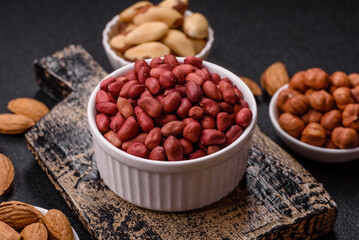 Peanuts or peeled graundnut in a bowl on a dark concrete background
