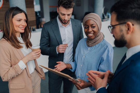 Business people discussing work in office during coffee break
